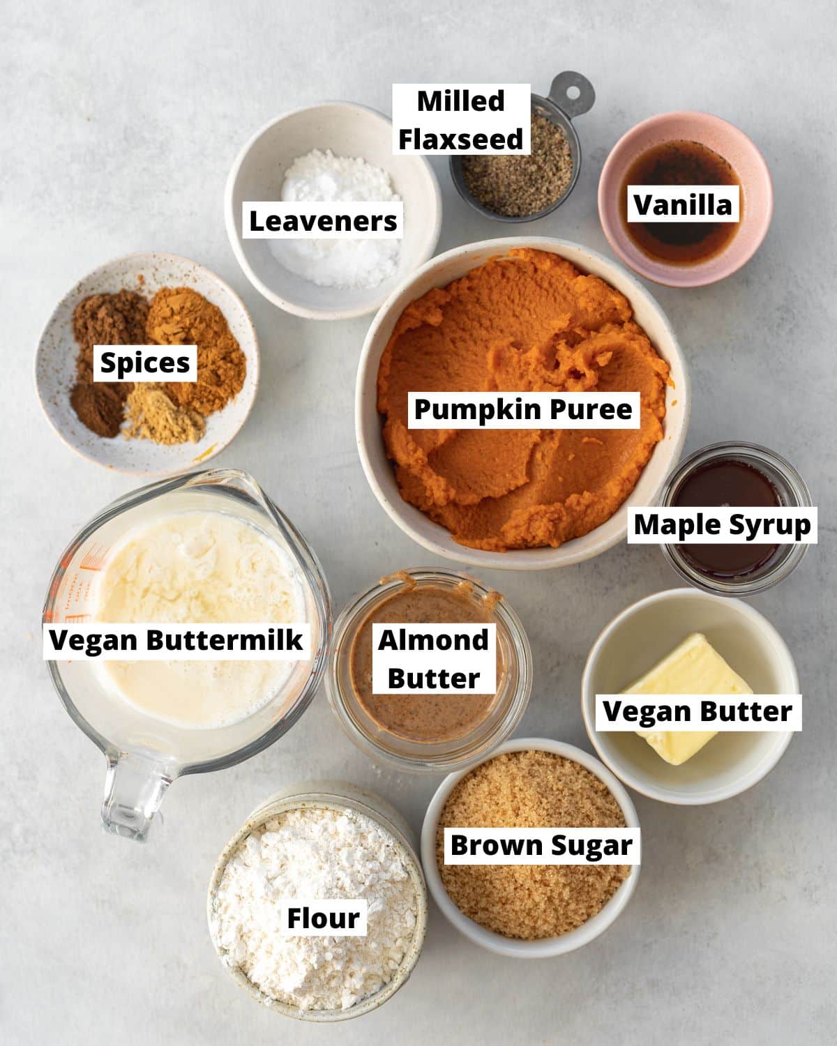 ingredients to make vegan pumpkin muffins measured out in bowls.