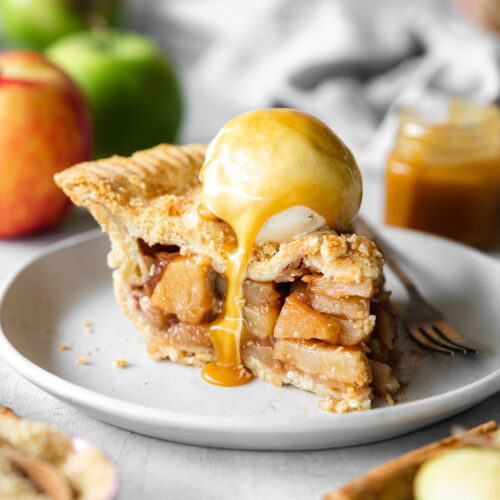 slice of apple pie with a scoop of vanilla ice cream and caramel sauce.
