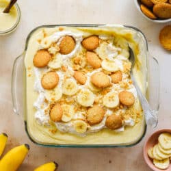 banana pudding with vanilla wafers and fresh banana in a clear baking dish.