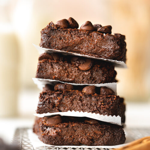 a stack of pumpkim brownies with milk bottles in the background.