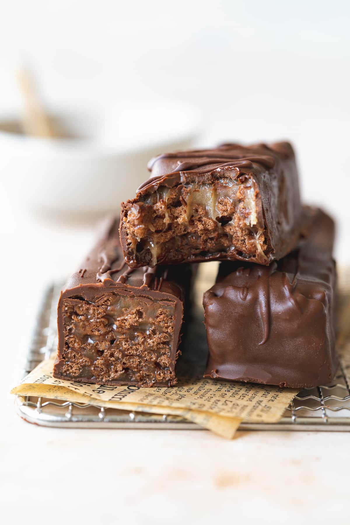 stack of toffee crisp bars on a wire rack with brown parchment paper underneath them.