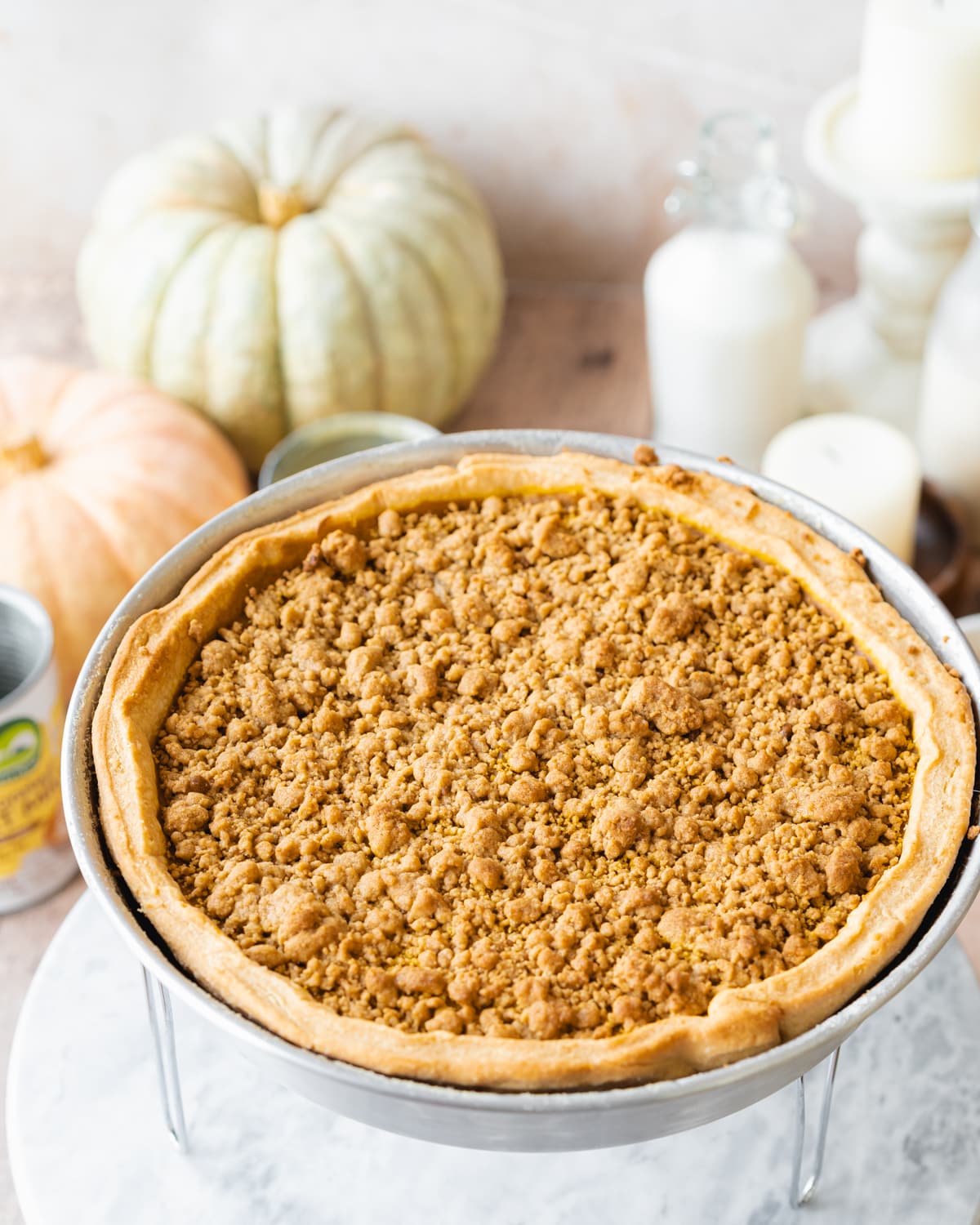 pumpkin pie with crumble topping and pumpkins in the background.