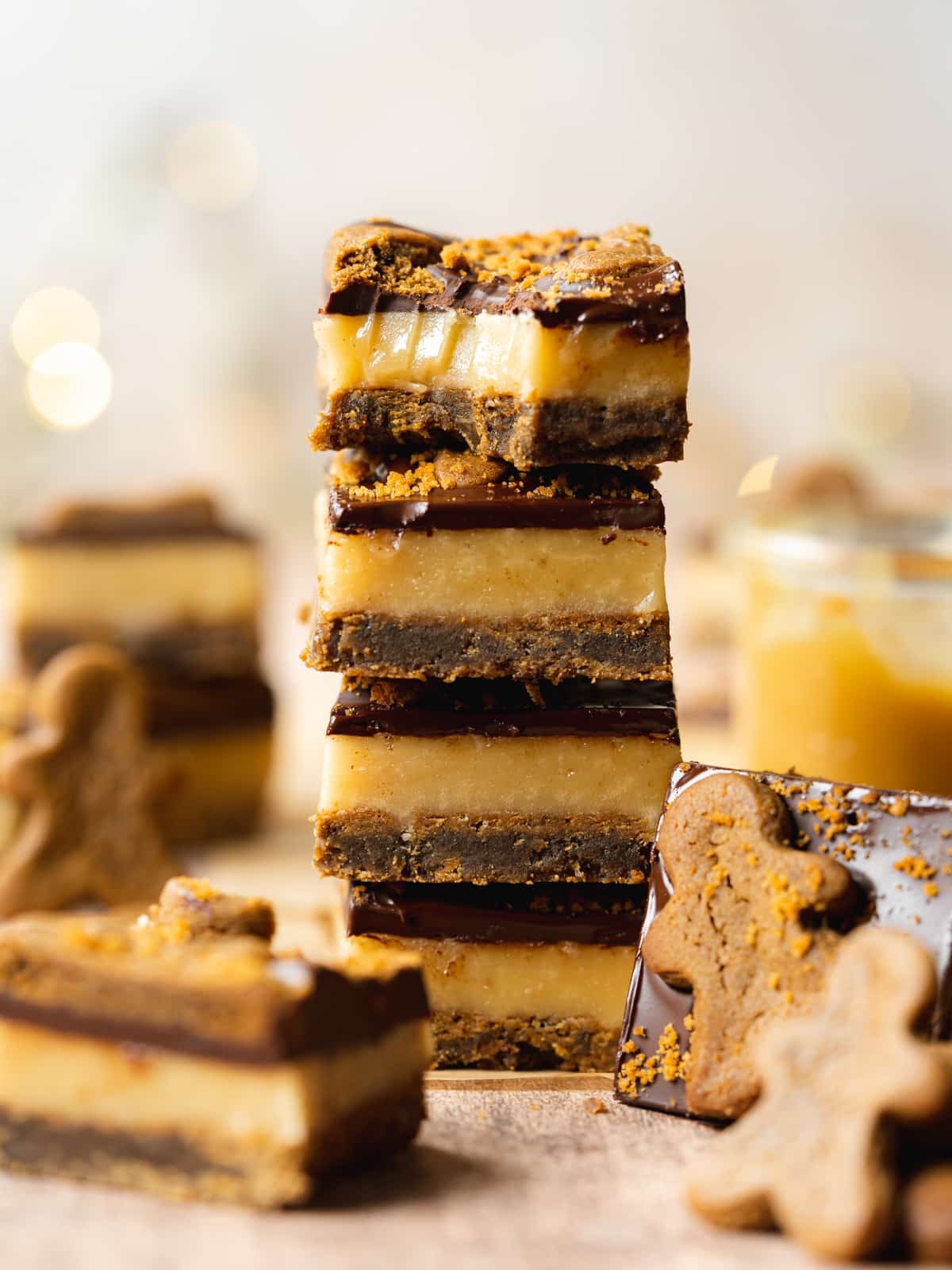 a stack of vegan caramel slices with gingerbread men scattered around.