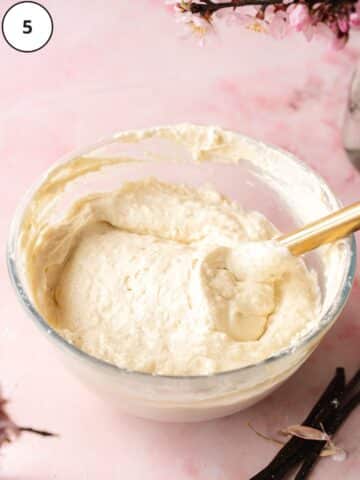 vegan vanilla cake batter folded in a large mixing bowl with a spatula.