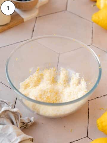 Lemon zest and sugar rubbed together in a mixing bowl.