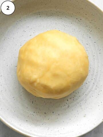 a ball of sweet pastry dough in a ceramic bowl.