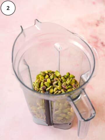 whole roasted pistachio nuts in a blender jug.