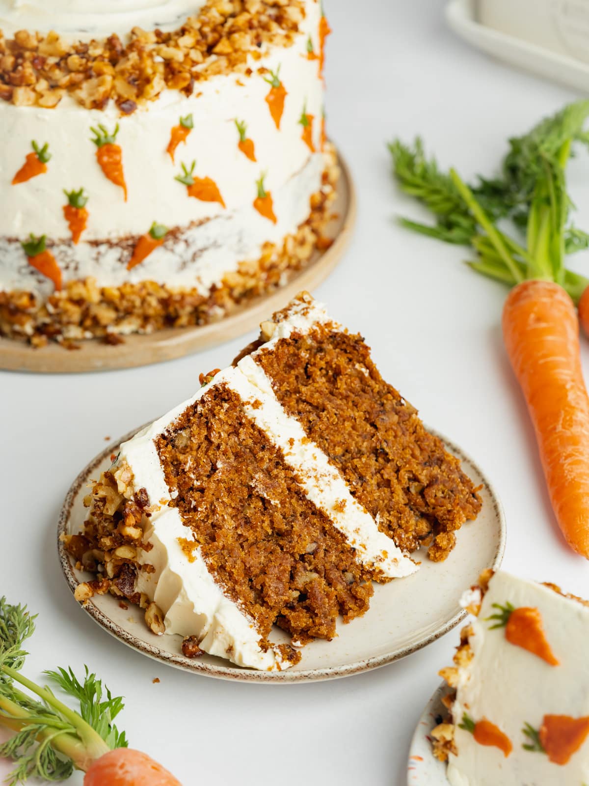 a slice of carrot cake on a ceramic plate.