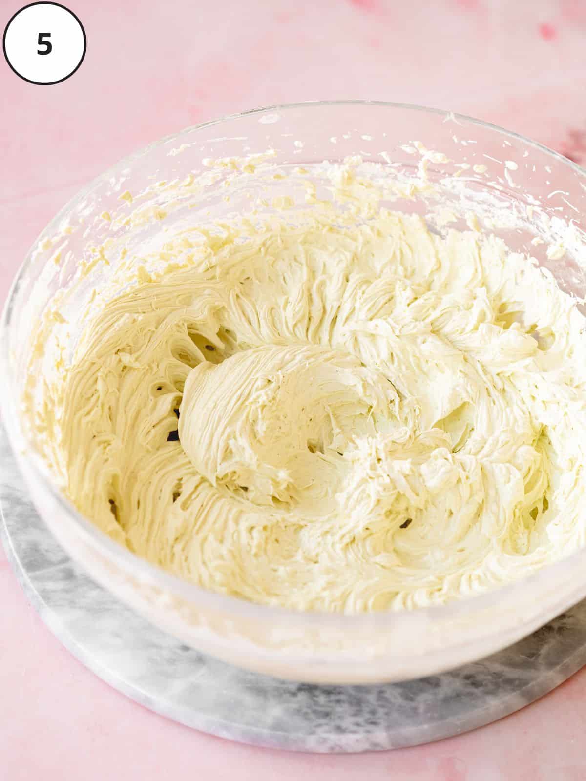 vegan pistachio buttercream in a large clear mixing bowl.