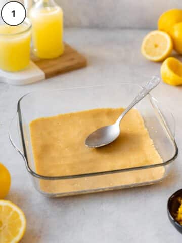 Blitzed vanilla sandwich cookie crust mixture flattened into the base of a glass dish.