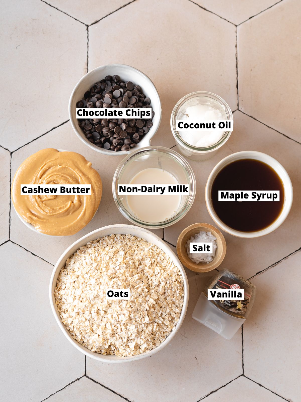 ingredients to make no bake cookie dough bars measured out in bowls on a tiled surface.