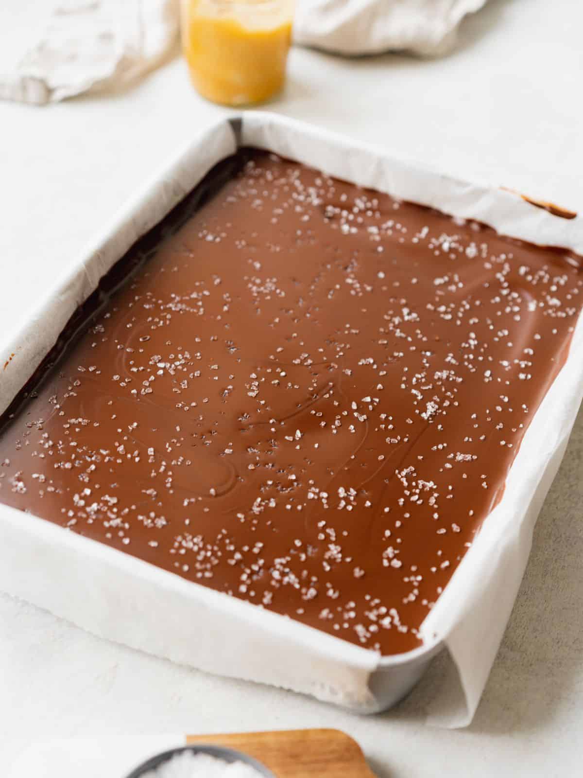 a tray of millionaire shortbread with a sprinkle of sea salt on top.