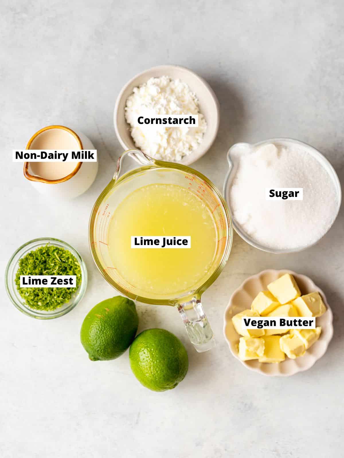 ingredients for homemade lime curd measured out in bowls on a gray surface.