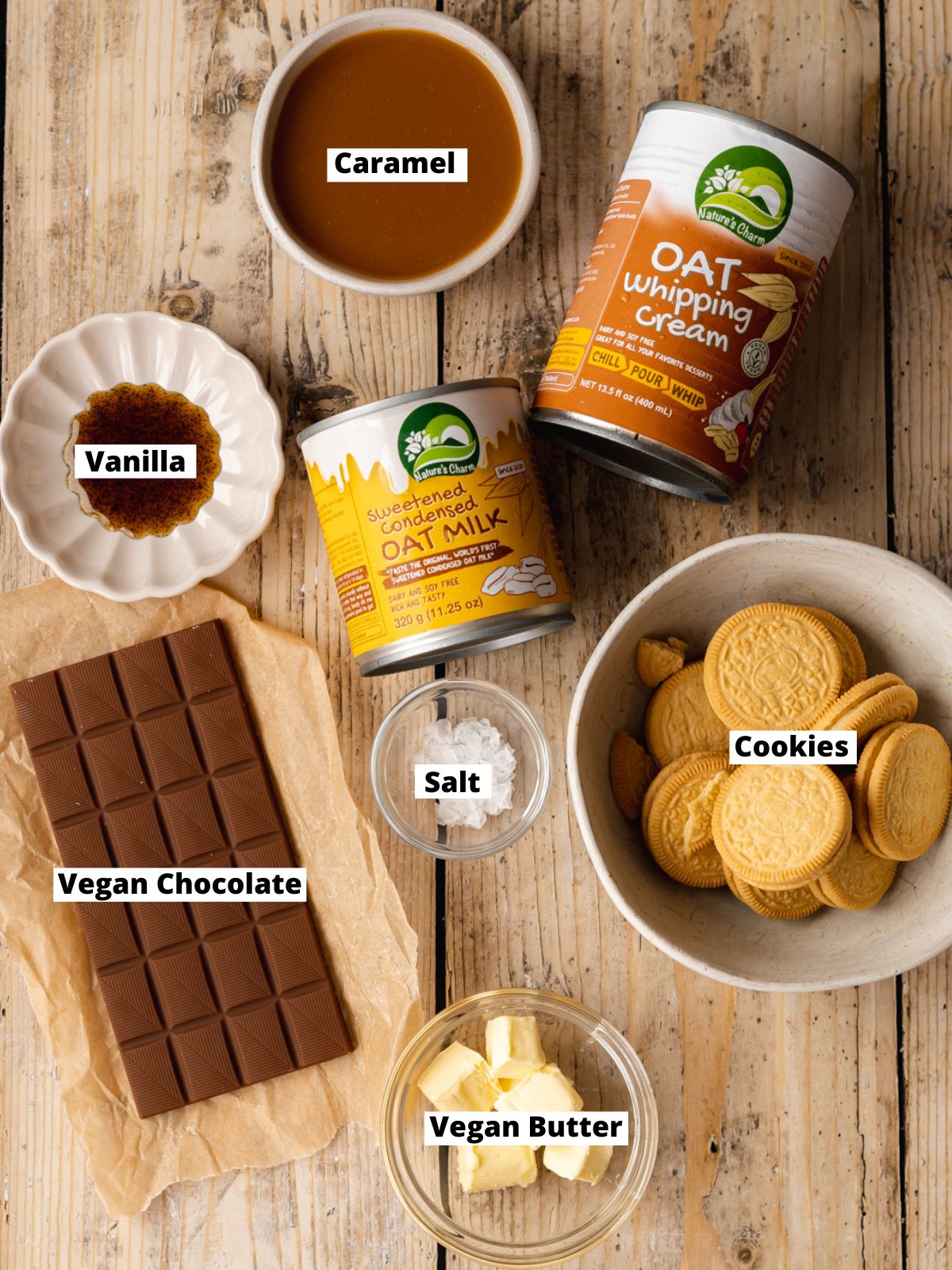 ingredients to make vegan twix ice cream bars measured out in bowls on a light wooden surface.