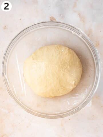 Vegan cinnamon roll dough after kneading until smooth and placed in a clean glass mixing bowl.