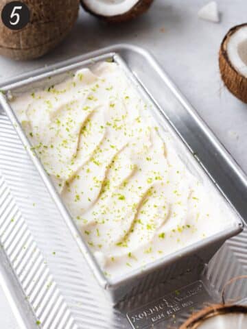 homemade coconut milk sorbet in a loaf pan with fresh lime zest on top.