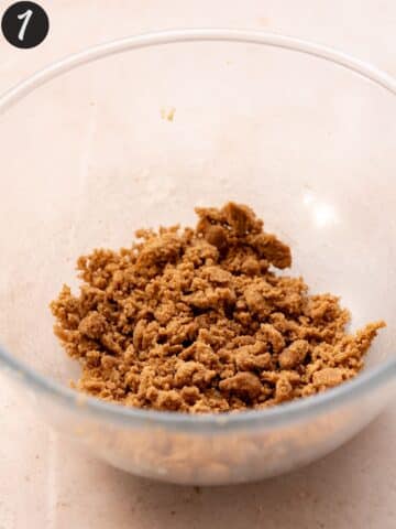 Pumpkin spice streusel topping mixture in a clear glass bowl.