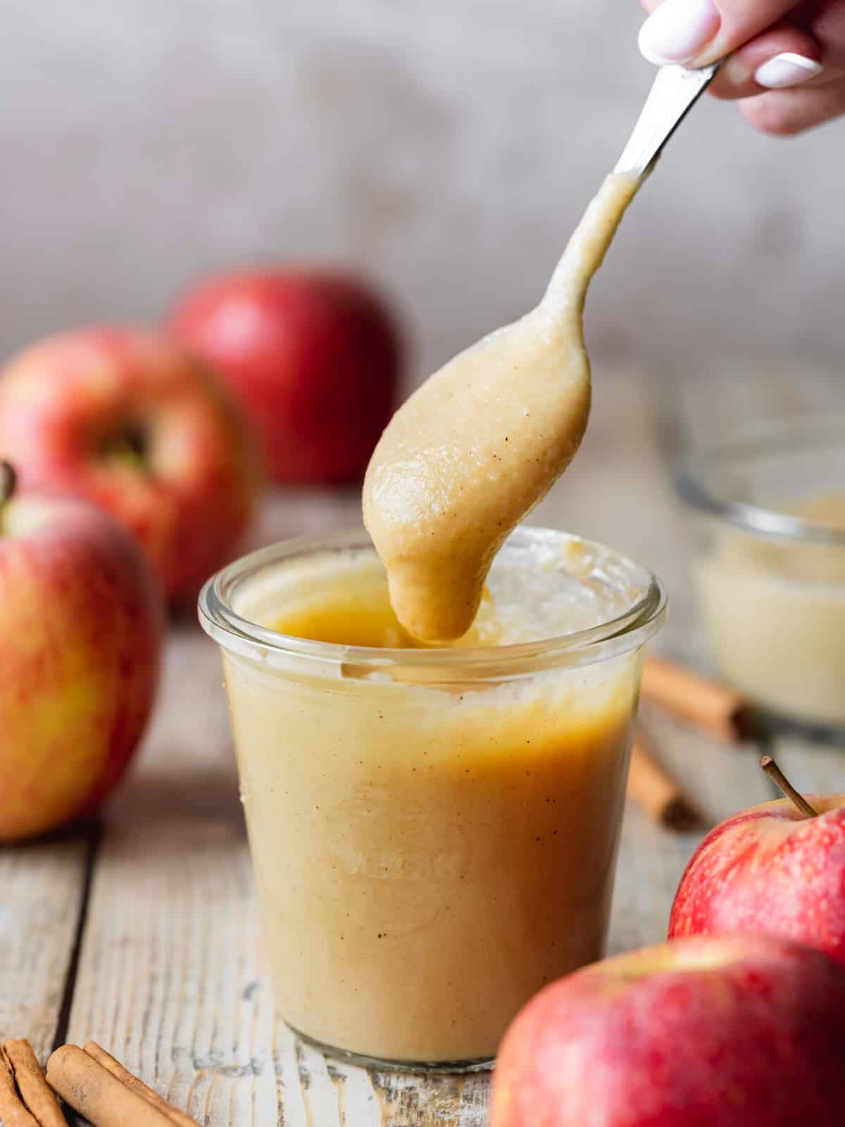 apple curd in a weck jar with a spoonful being lifted away showing the creamy consistency.