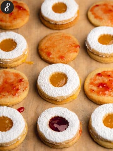 linzer cookies brushed with jam and topped with a sugar dusted cookie.
