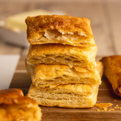 Stack of 4 baked pieces of vegan puff pastry from the side, showing the deliciously flaky layers.