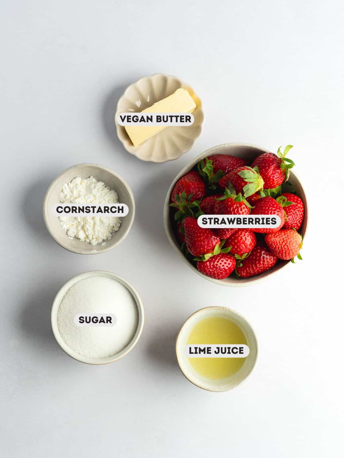 ingredients for strawberry curd measured out in bowls on a light gray surface with text overlay.