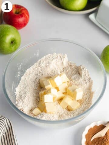 dry ingredients in a bowl with room temperature butter chunks.