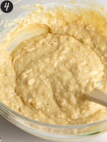 lemon muffin batter in a large mixing bowl with a spatula.