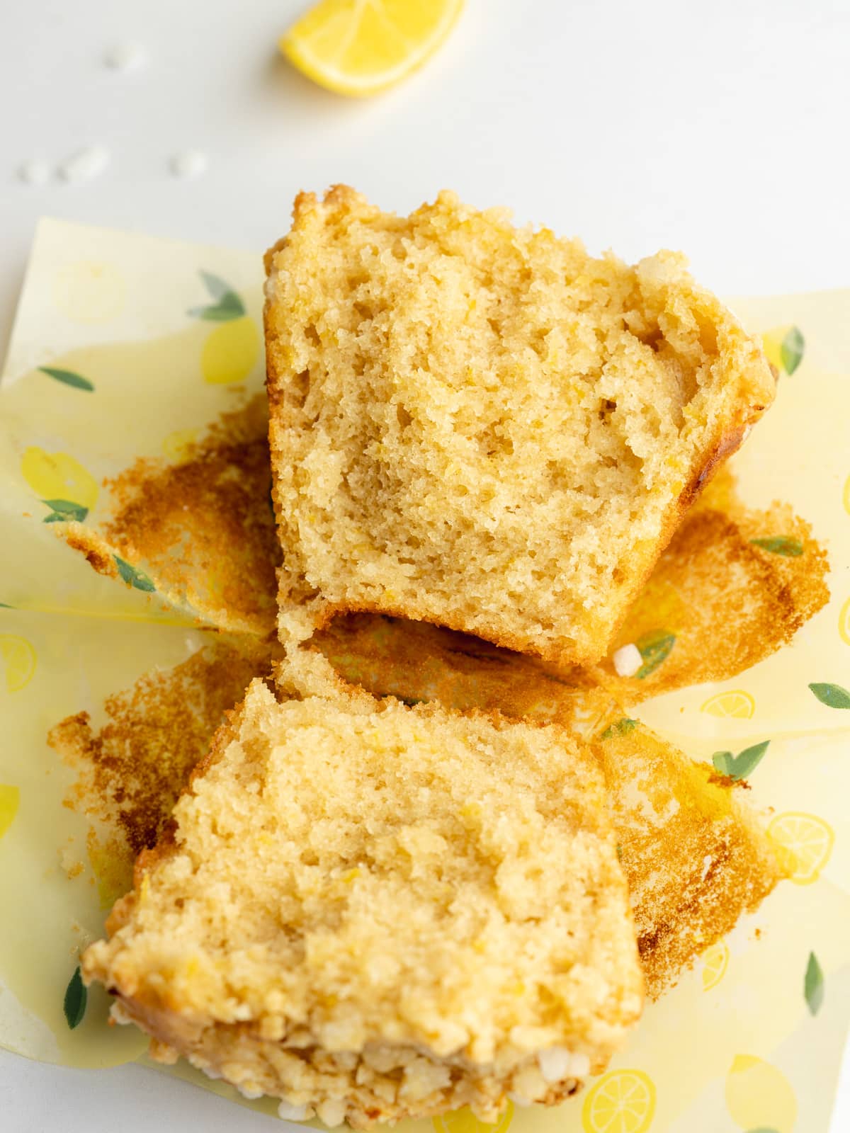 a lemon muffin that's been cut in half revealing the fluffy crumb.