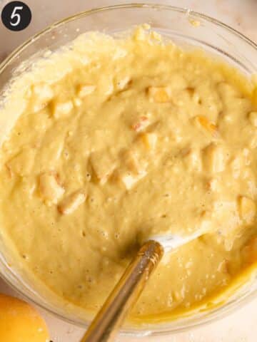 peach cobbler muffin batter with fresh peaches folded throughout.