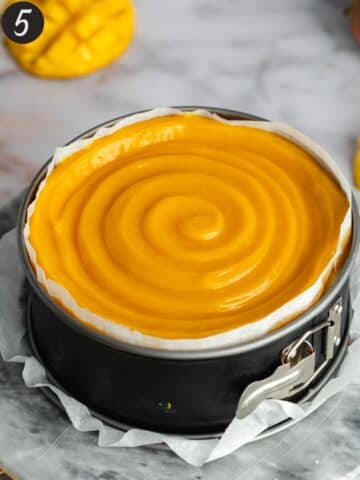 a set mango cheesecake with mango topping swirled on top.