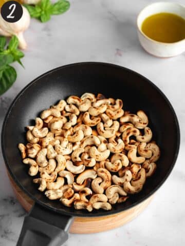 cashews being toasted in a pan until browned.