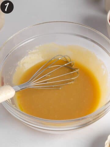 a large mixing bowl with sugar, yogurt, olive oil, and vanilla whisked together.