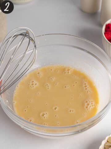 wet ingredients for raspberry muffins whisked in a large bowl.