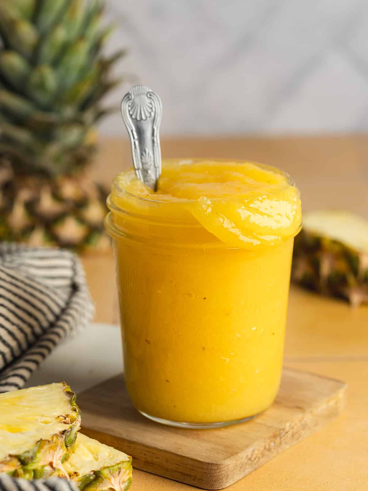 a ball mason jar filled with bright yellow pineapple curd.