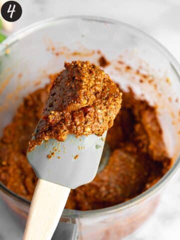 smooth red pesto on a rubber spatula showing the thick consistency.