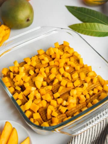 cookies and mango pieces layered in a glass dish.