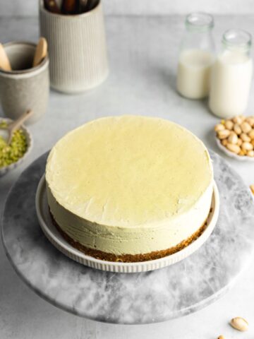 a no bake pistachio cheesecake on a marble turntable.