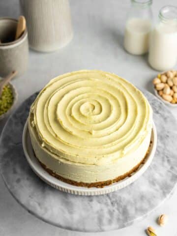 pistachio cheesecake with swirl of white chocolate ganache on top.