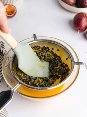 pressing passion fruit pulp through a fine-mesh sieve to separate the seeds.