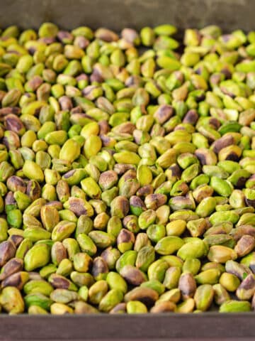 peeled and roasted pistachios on a baking tray.