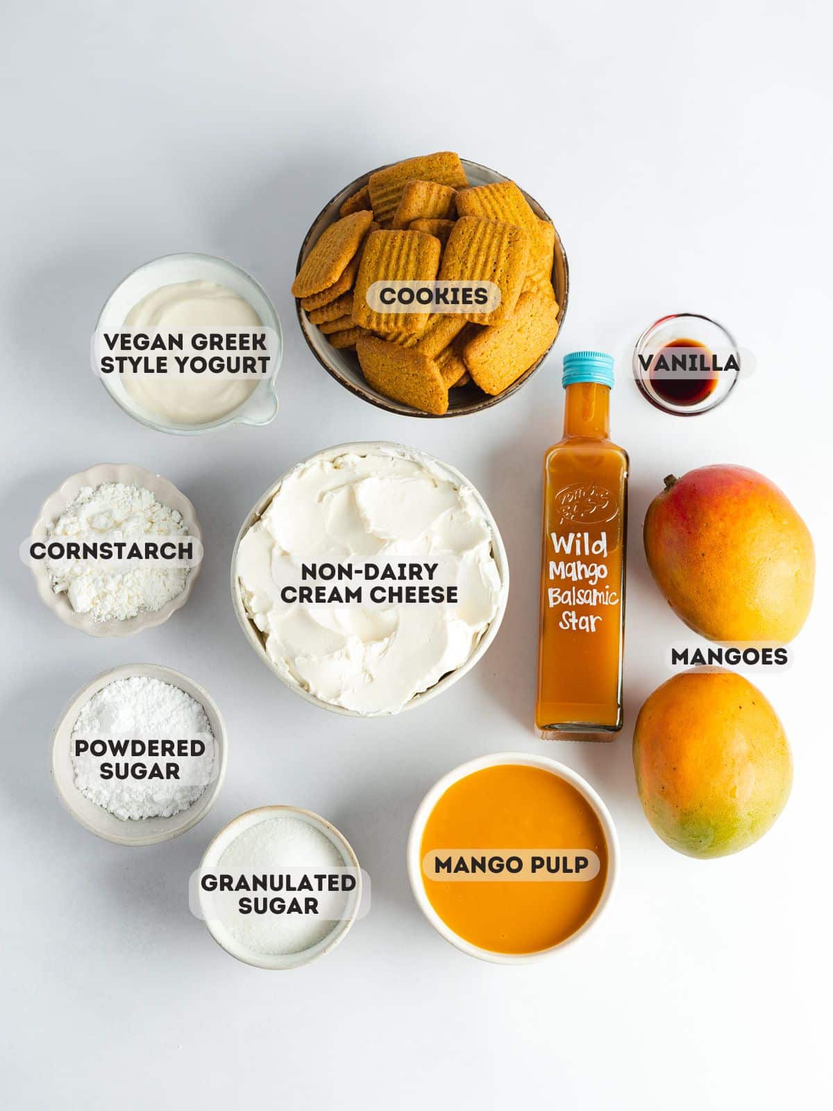 ingredients for mango tiramisu measured out in bowls on a marble surface.