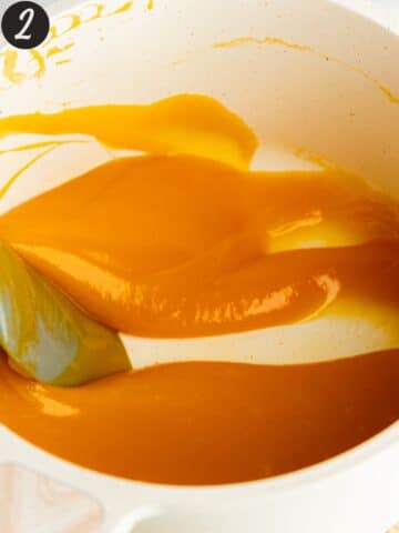 mango curd in a saucepan with a spatula showing the thick consistency.