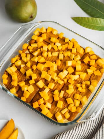 layered mango tiramisu with mango chunks on top.