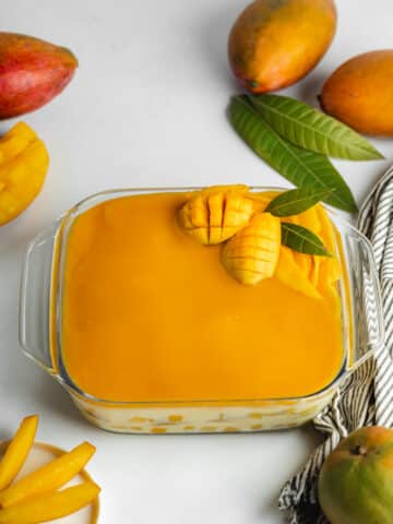 mango tiramisu with mango curd topping in a glass dish before serving.