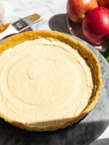 a baked tart shell filled with frangipane before being topped with apples.
