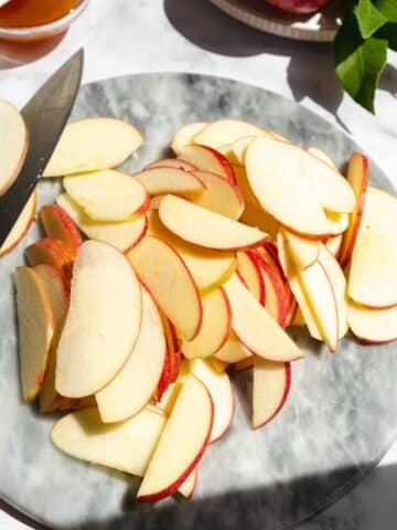apples sliced on top of a marble surface.