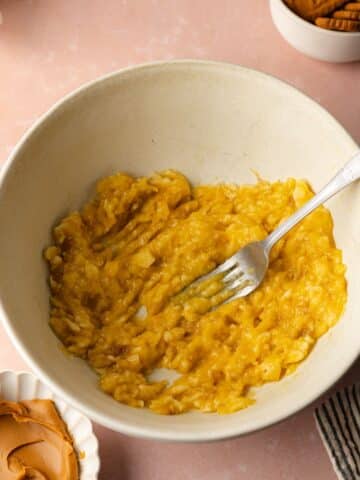 banana mashed with a fork in a large bowl.