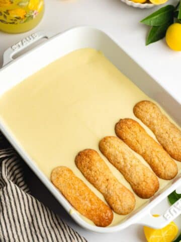 a lemon tiramisu with some limoncello dipped ladyfingers layered on top of half of it.