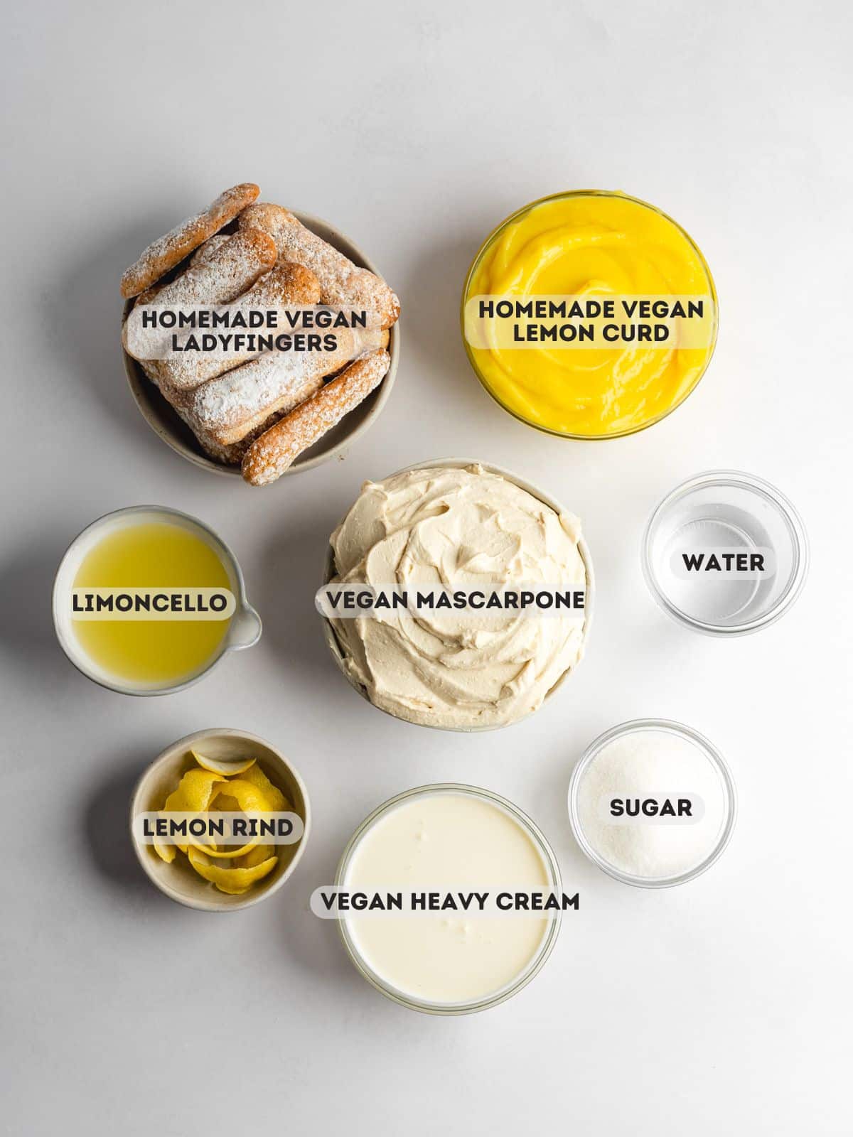 ingredients to make vegan limoncello tiramisu measured out in bowls on a gray surface.