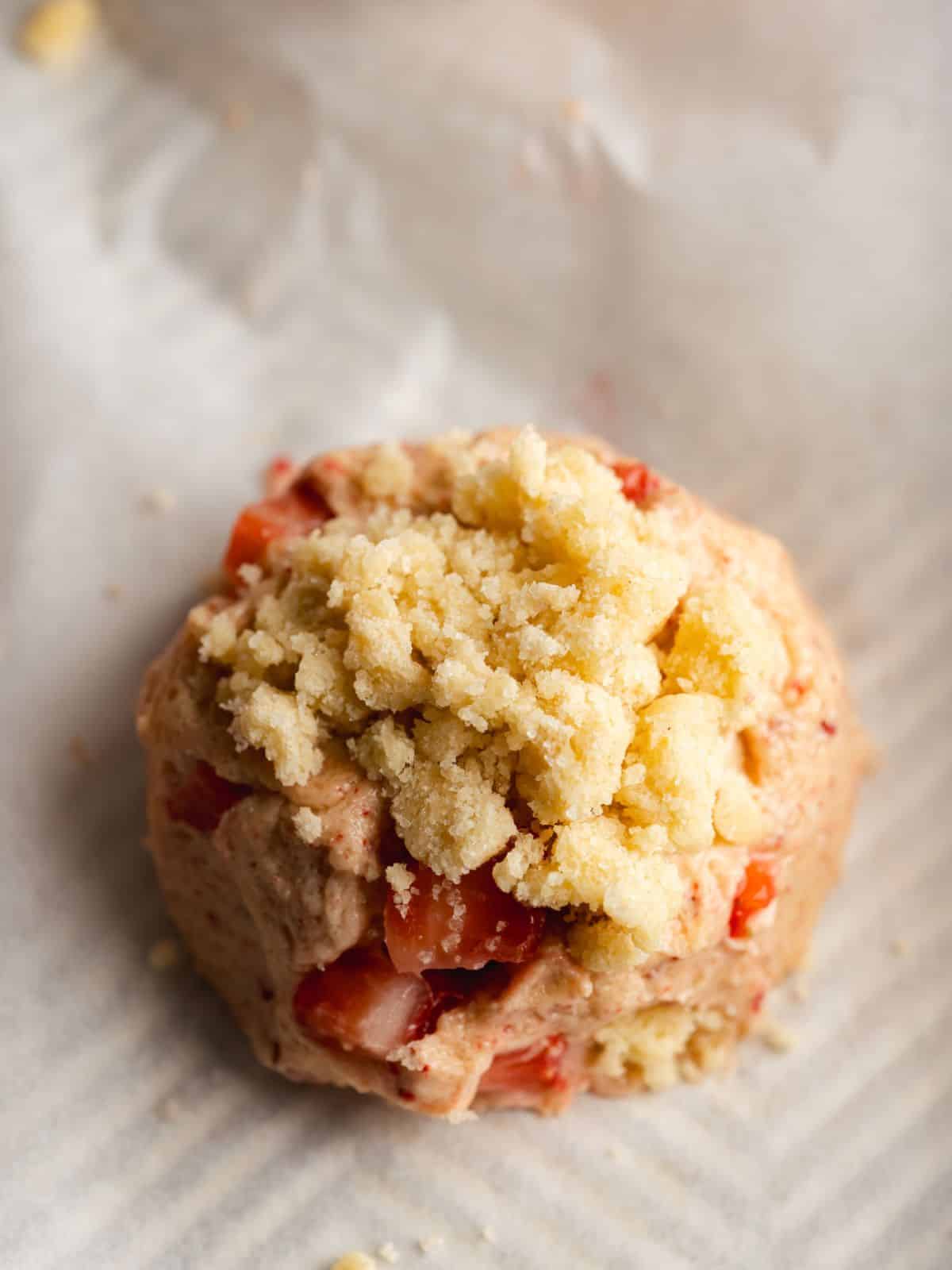 a shortcake cookie dough ball on a parchment lined baking sheet before going into the oven.